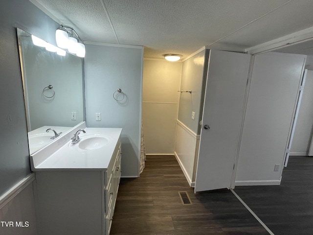 bathroom with vanity, hardwood / wood-style floors, and a textured ceiling