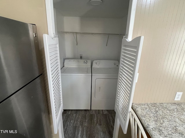 washroom with wood walls, washing machine and dryer, and dark hardwood / wood-style floors