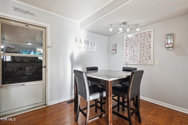 dining space with crown molding and dark wood-type flooring