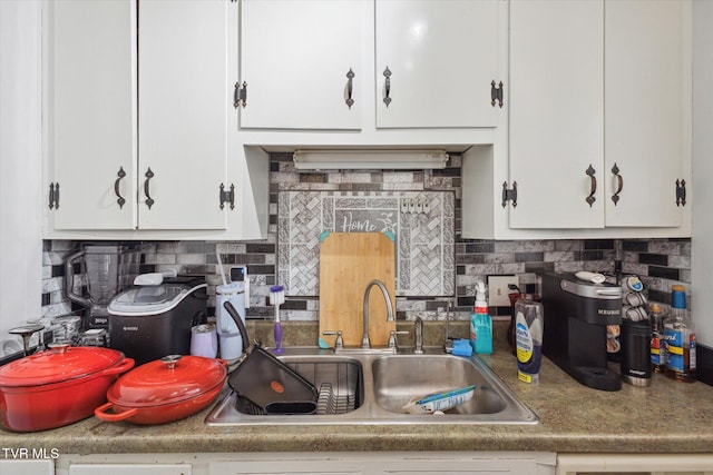 kitchen featuring white cabinetry, sink, and backsplash