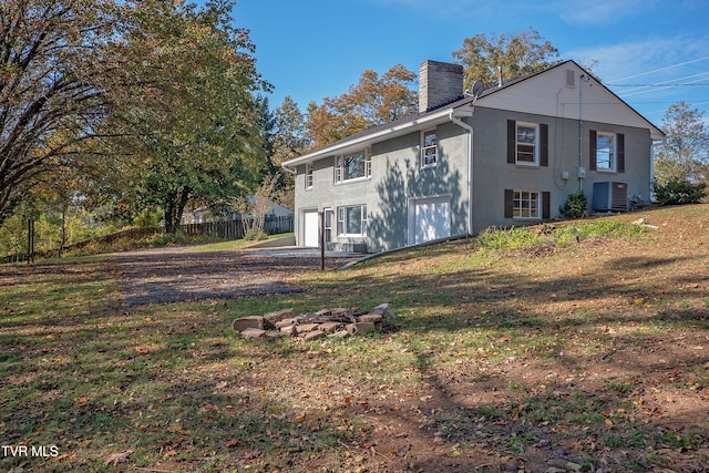 rear view of property with central AC and a yard