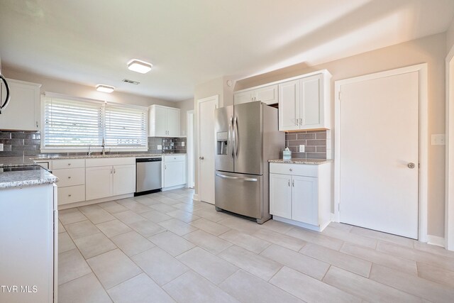 kitchen with white cabinetry, stainless steel appliances, sink, and tasteful backsplash