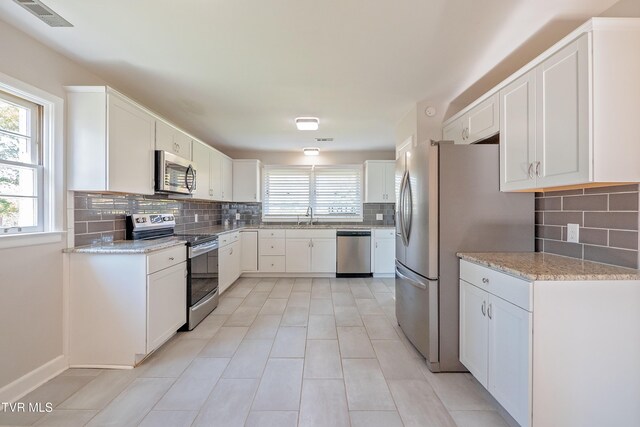 kitchen with white cabinetry, appliances with stainless steel finishes, sink, and tasteful backsplash