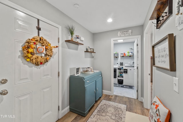 clothes washing area featuring hardwood / wood-style flooring and separate washer and dryer