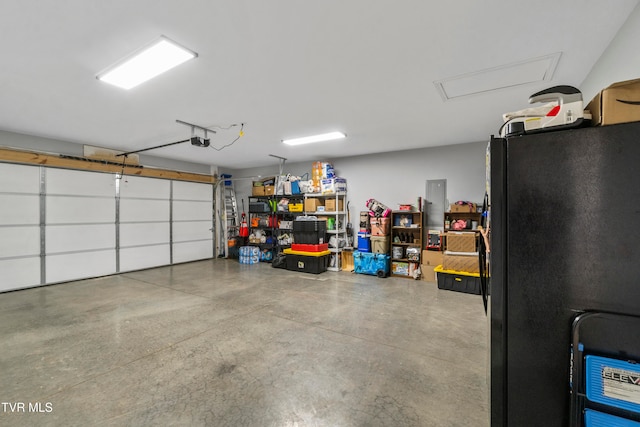 garage with a garage door opener and black fridge