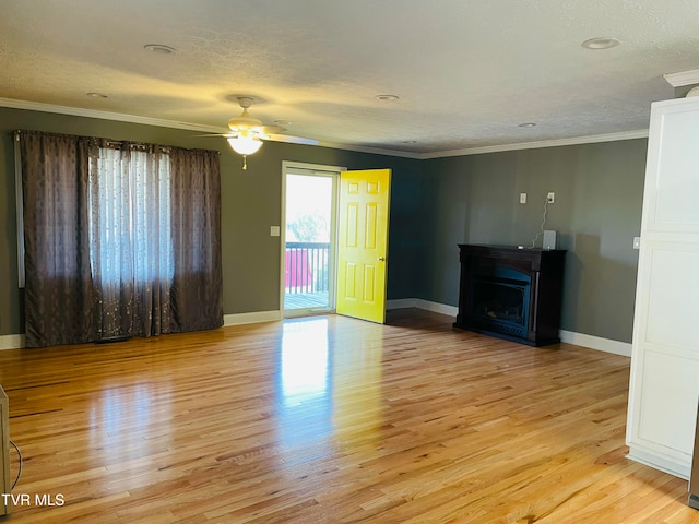 unfurnished living room with a fireplace, ornamental molding, light wood-type flooring, and ceiling fan