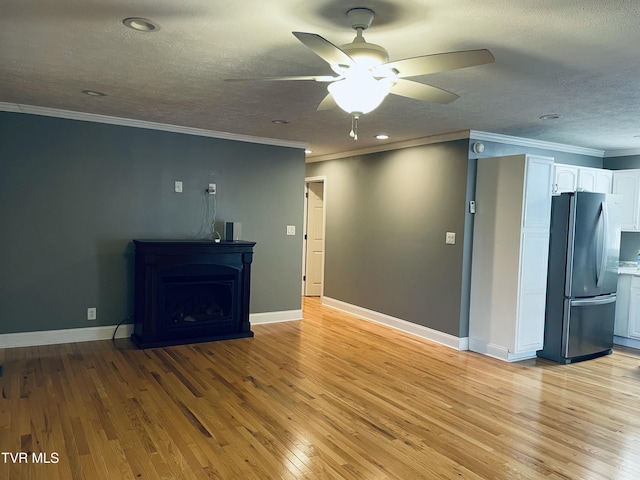 unfurnished living room with a ceiling fan, a textured ceiling, baseboards, crown molding, and light wood-style floors
