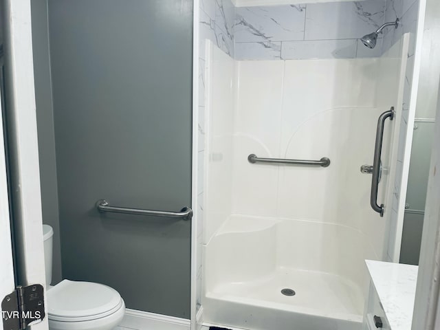 bathroom with vanity, toilet, and a shower stall