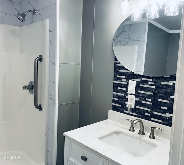 bathroom featuring vanity, backsplash, and an enclosed shower