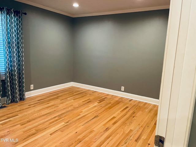 spare room with light hardwood / wood-style floors and crown molding