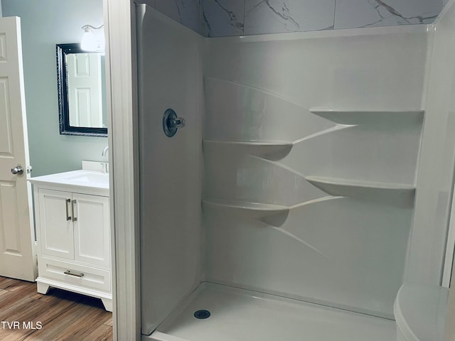 bathroom with vanity, walk in shower, toilet, and wood-type flooring