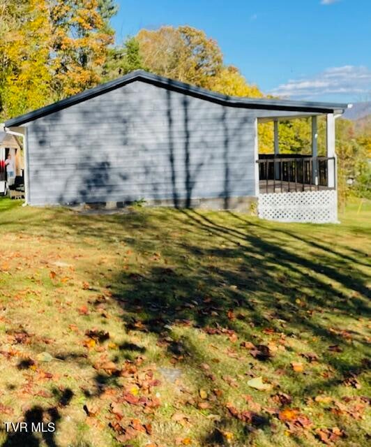 view of side of property featuring a yard and a sunroom