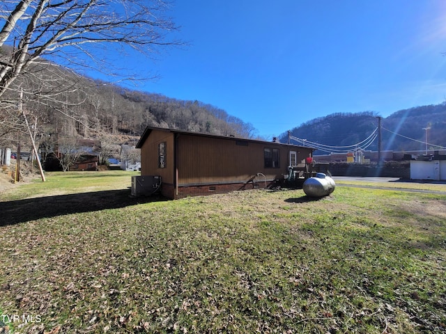 view of side of home featuring a mountain view and a lawn