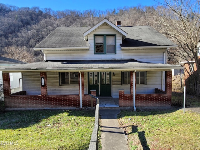 view of front facade featuring a front yard and covered porch