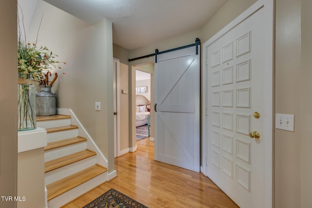 entrance foyer with a barn door and light wood-type flooring