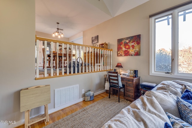 bedroom featuring wood-type flooring, multiple windows, and an inviting chandelier