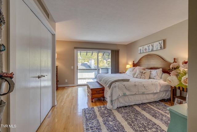 bedroom with a closet, light hardwood / wood-style flooring, and access to outside