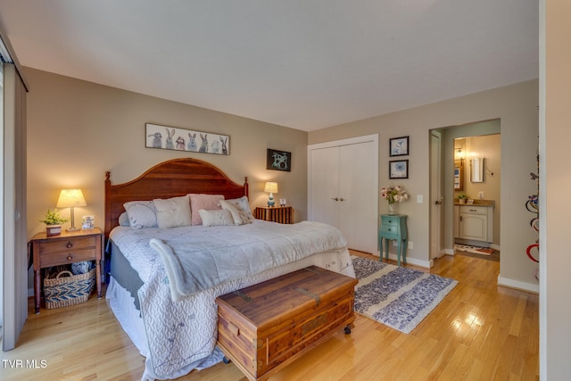 bedroom with light hardwood / wood-style flooring and ensuite bath