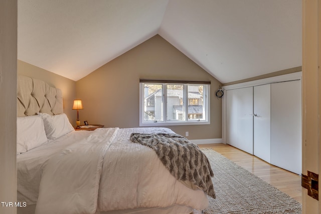 bedroom featuring a closet, vaulted ceiling, and light hardwood / wood-style floors