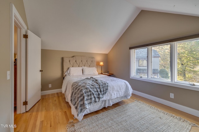 bedroom with vaulted ceiling and light hardwood / wood-style flooring