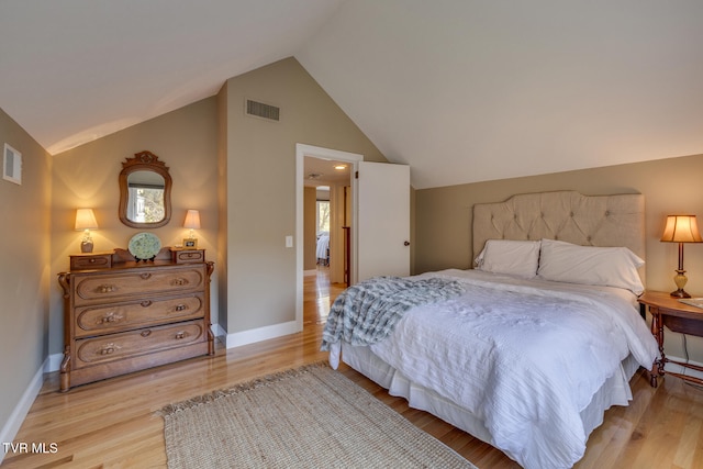 bedroom featuring light hardwood / wood-style flooring, multiple windows, and vaulted ceiling