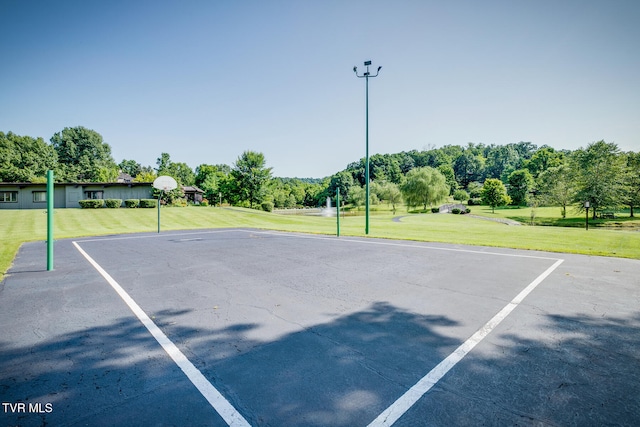 view of sport court with a lawn