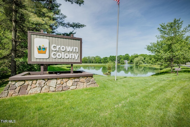 community sign with a yard and a water view