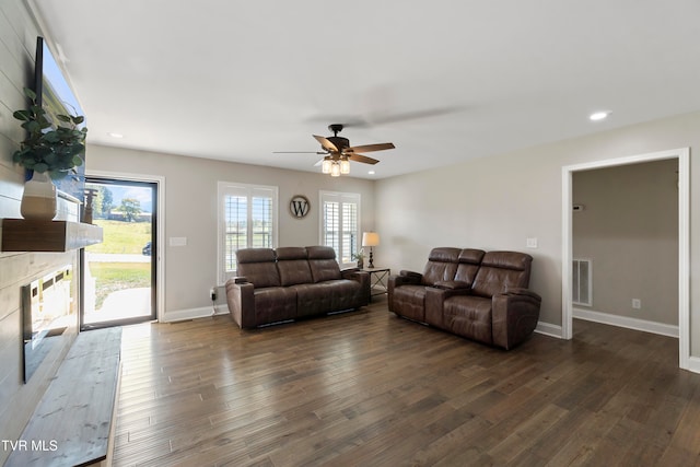 living room featuring ceiling fan and dark hardwood / wood-style flooring