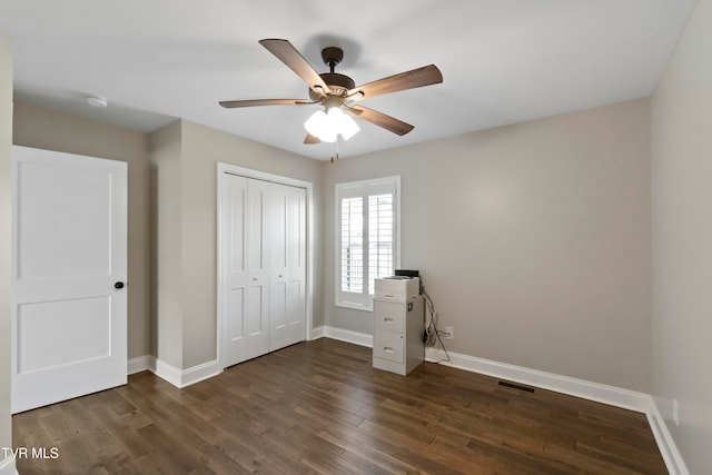 unfurnished bedroom featuring a closet, dark wood-type flooring, and ceiling fan