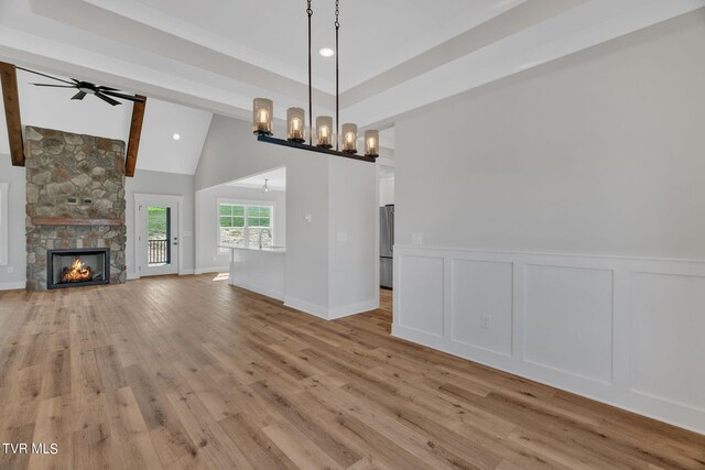 633 Uncle Buddys Way, Jonesborough, TN 37659 - unfurnished living room featuring light wood-style flooring, a ceiling fan, a decorative wall, a fireplace, and a chandelier