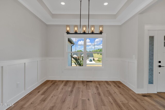 633 Uncle Buddys Way, Jonesborough, TN 37659 - unfurnished dining area with a raised ceiling, light wood-style flooring, a chandelier, wainscoting, and crown molding