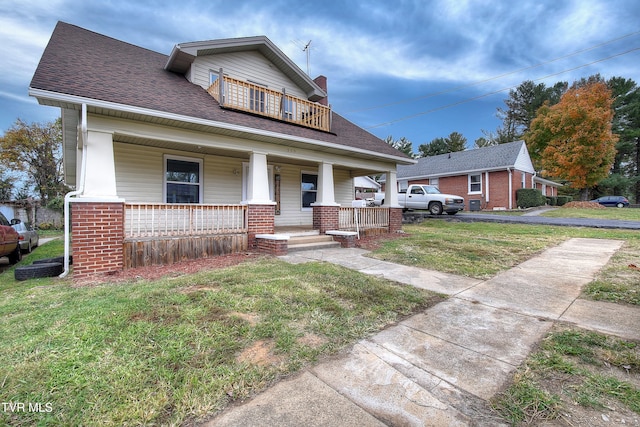 bungalow featuring covered porch and a front yard