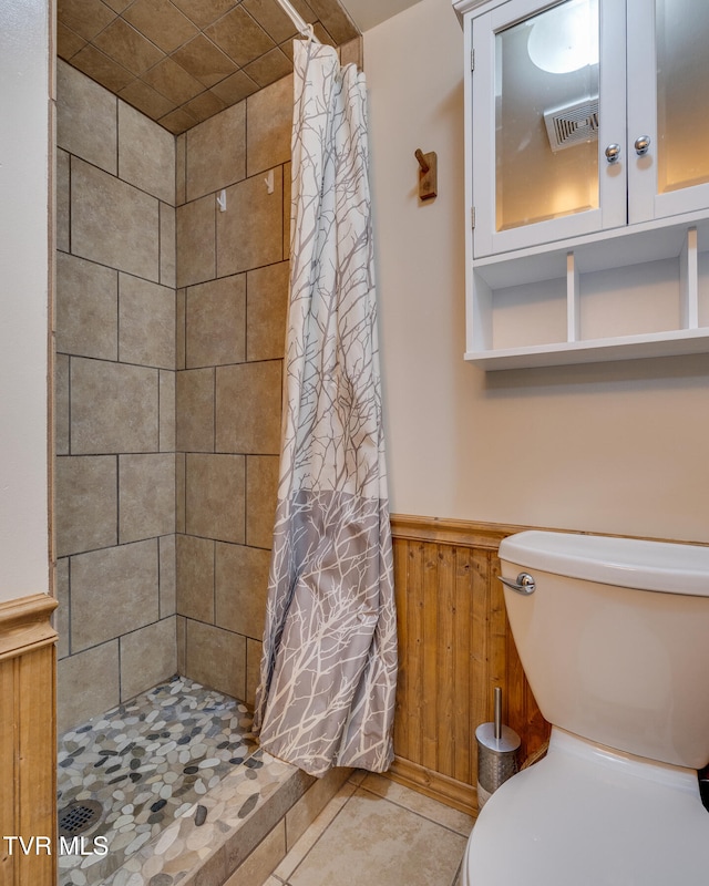 bathroom with toilet, wood walls, tile patterned floors, and a shower with shower curtain