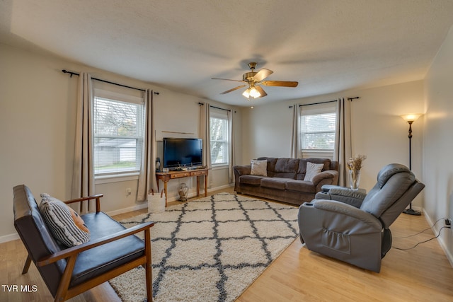 living room featuring a wealth of natural light, a textured ceiling, light hardwood / wood-style floors, and ceiling fan