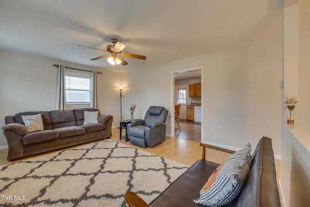 living room with light wood-type flooring, a healthy amount of sunlight, and ceiling fan