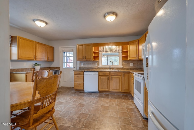 kitchen featuring sink, a textured ceiling, white appliances, and tasteful backsplash