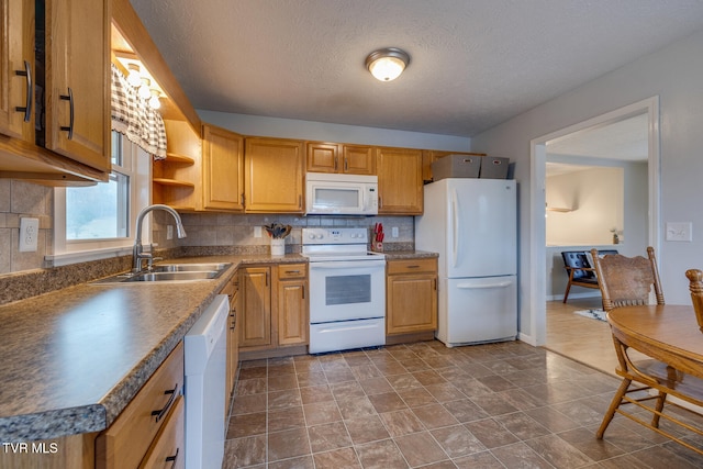 kitchen featuring sink, a textured ceiling, white appliances, and tasteful backsplash