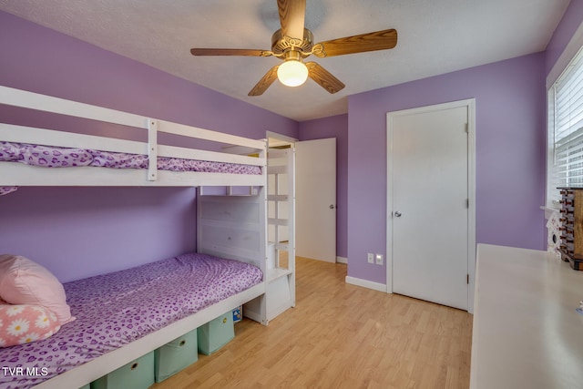 bedroom with ceiling fan, a textured ceiling, and light hardwood / wood-style floors