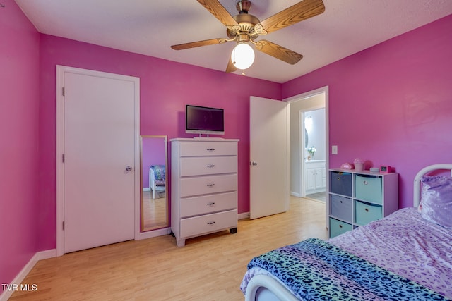 bedroom featuring connected bathroom, ceiling fan, and light wood-type flooring