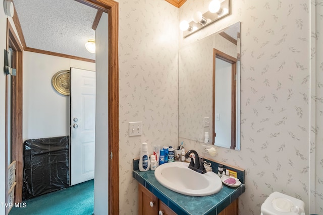 bathroom featuring vanity, ornamental molding, a textured ceiling, and toilet