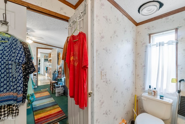 bathroom featuring toilet, ornamental molding, a textured ceiling, and ceiling fan