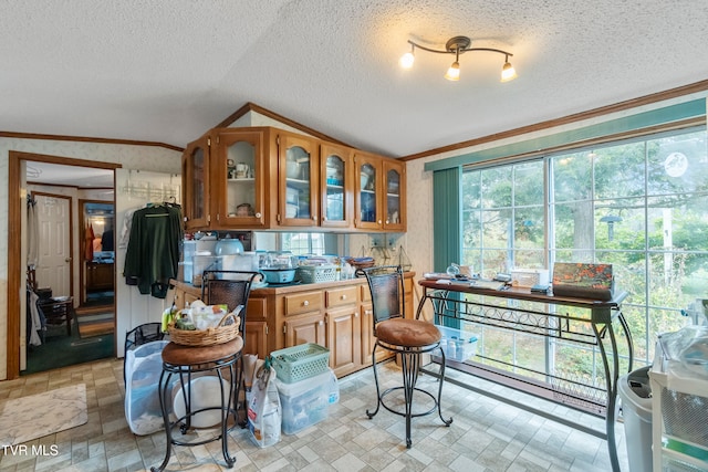 kitchen featuring crown molding, a textured ceiling, and lofted ceiling