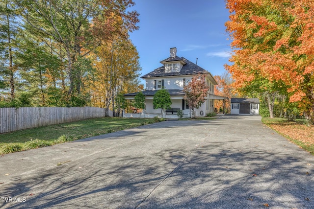 view of front of house with a front lawn, fence, stucco siding, a chimney, and concrete driveway