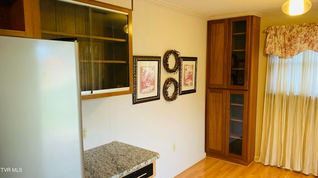 hall with ornamental molding and light hardwood / wood-style flooring