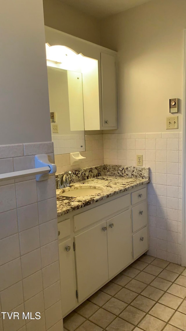 bathroom with tile patterned flooring, vanity, and tile walls