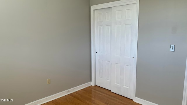 unfurnished bedroom featuring hardwood / wood-style floors and a closet