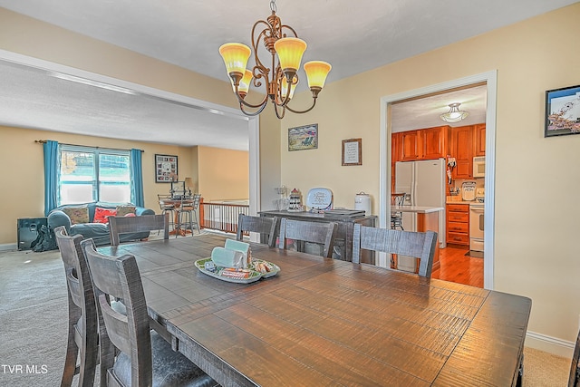 carpeted dining area featuring a chandelier