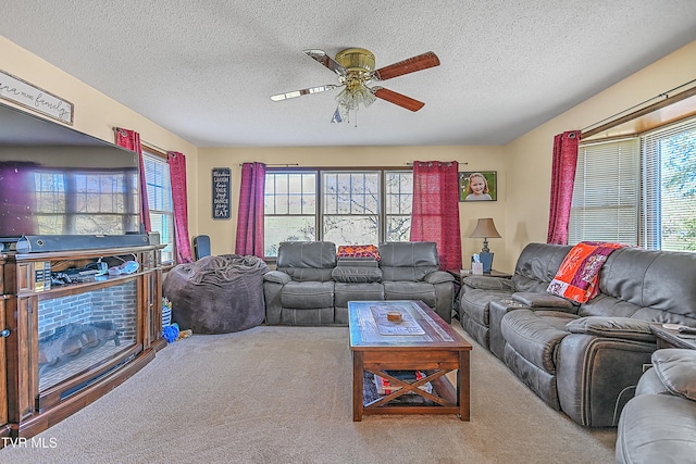 living room featuring ceiling fan, a textured ceiling, and plenty of natural light