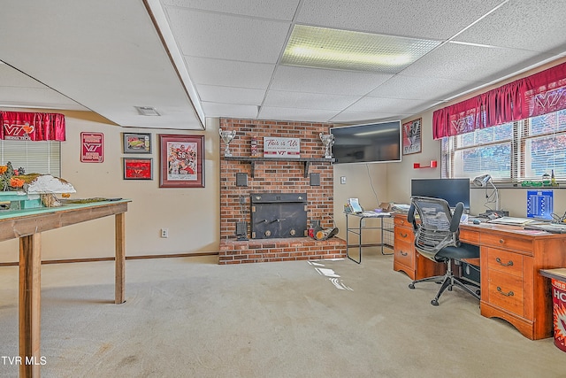 home office featuring a paneled ceiling, light carpet, and a brick fireplace