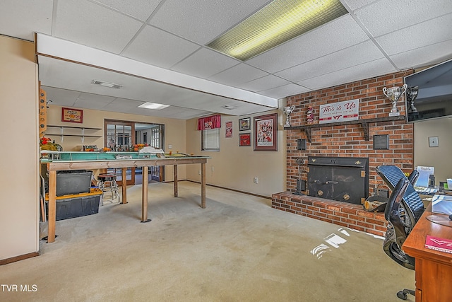 rec room with a brick fireplace, a paneled ceiling, and carpet flooring